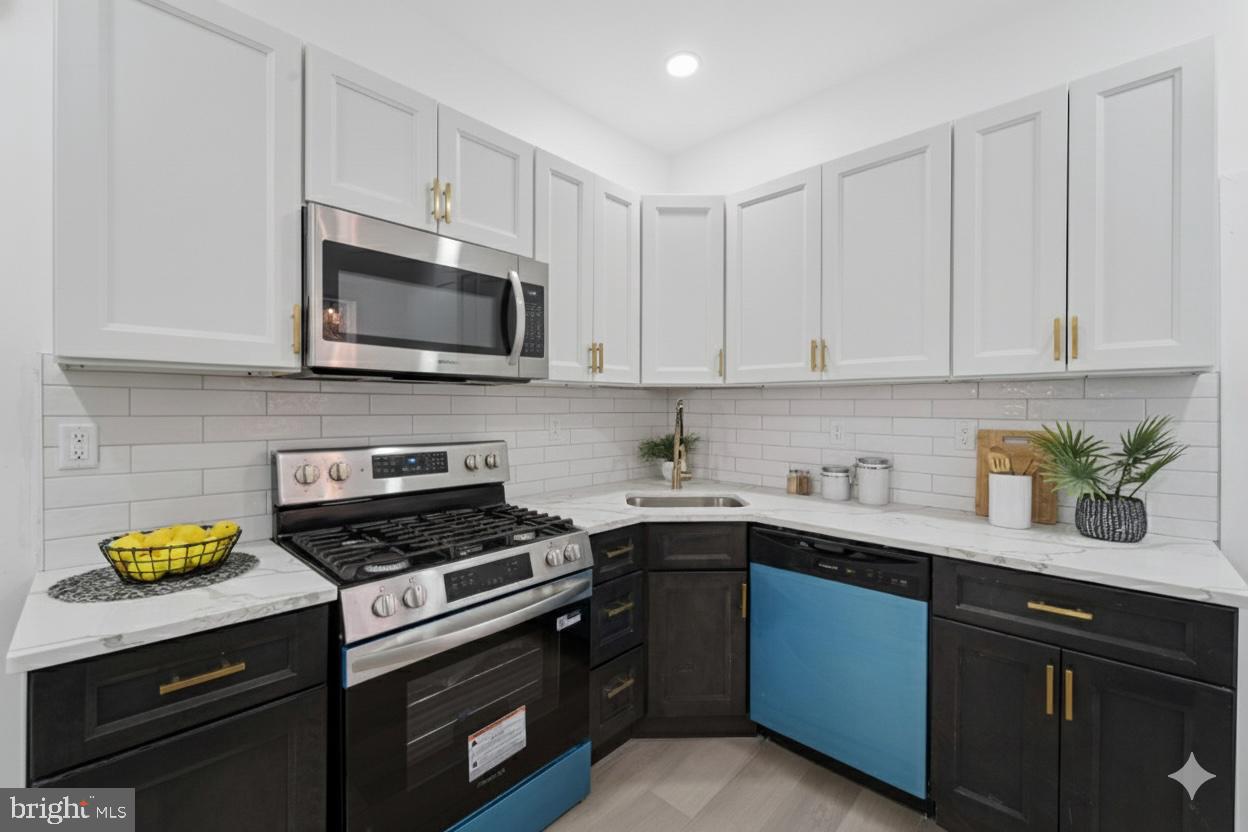 537 North Wanamaker Street Philadelphia, PA 19131 - Photo 12 of 37 a kitchen with stainless steel appliances granite countertop grey cabinets a stove a sink and dishwasher