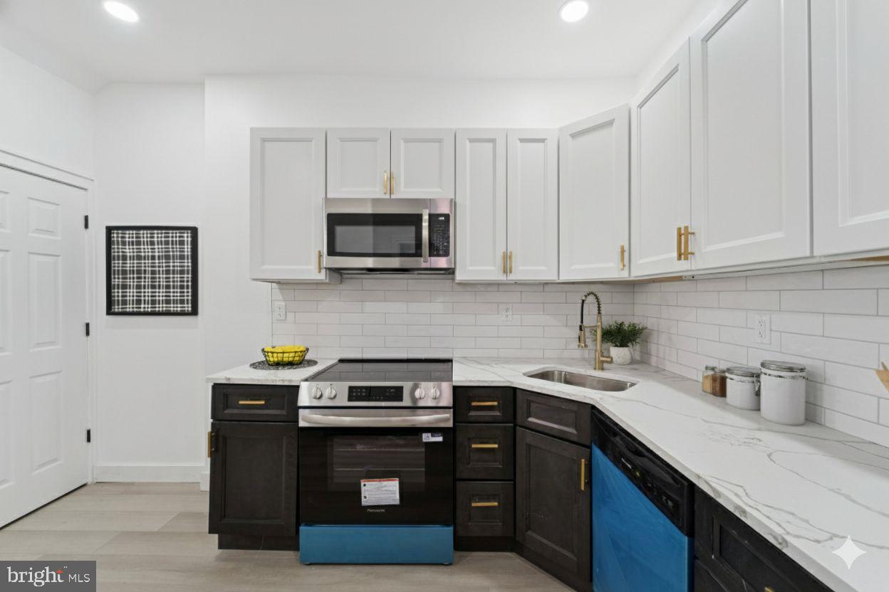 537 North Wanamaker Street Philadelphia, PA 19131 - Photo 13 of 37 a kitchen with stainless steel appliances granite countertop a sink a stove a microwave and cabinets