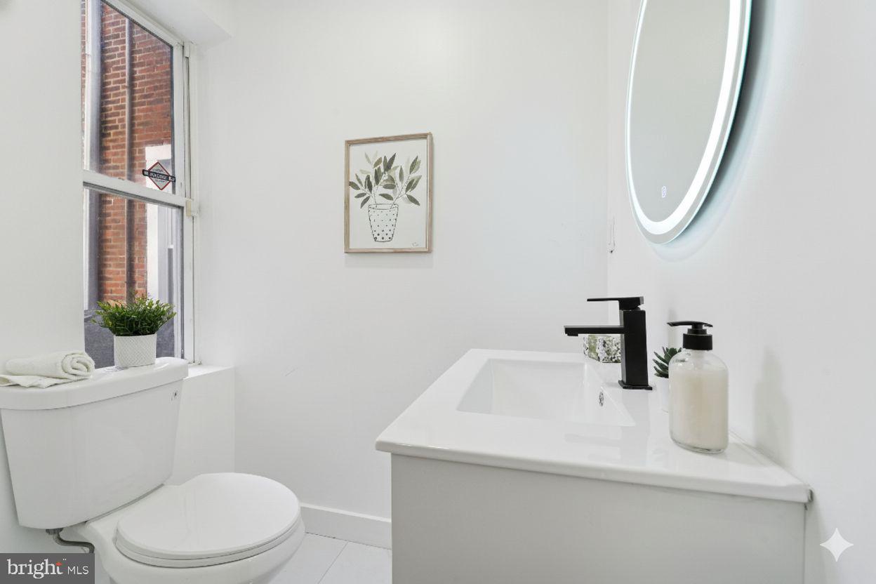 537 North Wanamaker Street Philadelphia, PA 19131 - Photo 14 of 37 a bathroom with a sink a toilet and a mirror