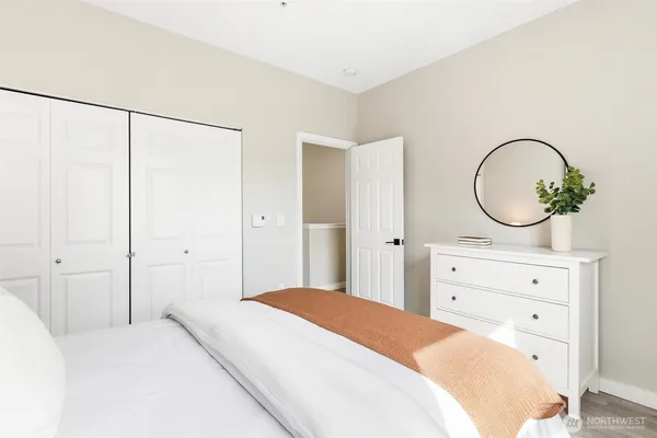 a bedroom with a bed a mirror and a dresser
