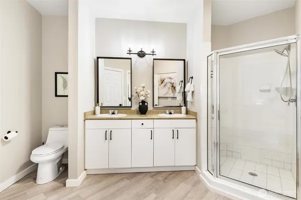 a bathroom with a granite countertop sink toilet a mirror and shower