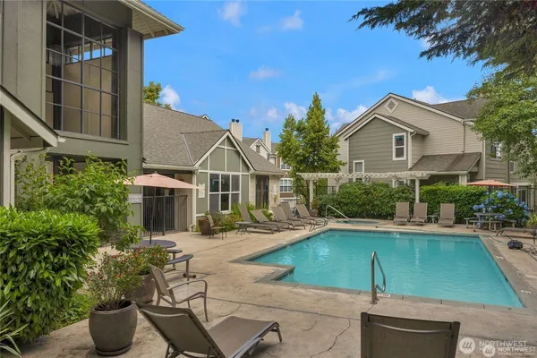 a view of a house with swimming pool and sitting area