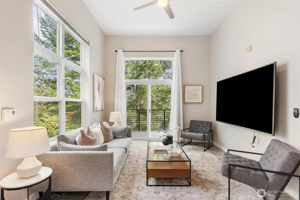 a living room with furniture a flat screen tv and a large window