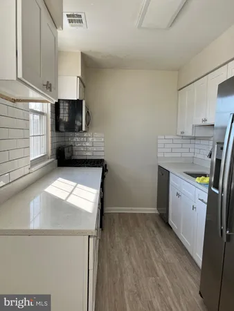 a kitchen with a sink a stove and cabinets