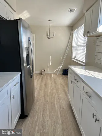 a kitchen with a refrigerator a sink and wooden floor