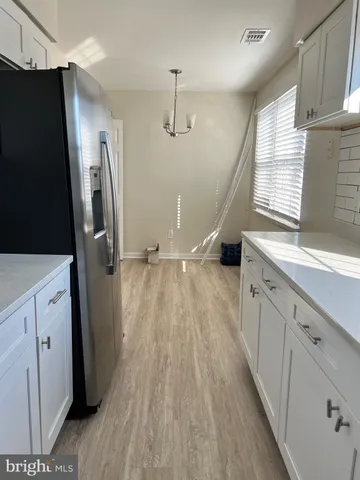 a kitchen with a refrigerator a sink and wooden floor