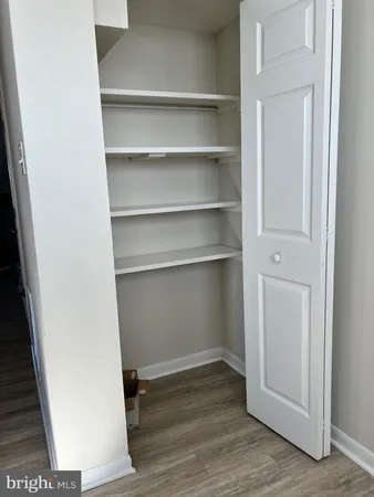 a view of walk in closet with empty racks