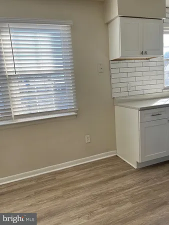 a view of a kitchen with wooden floor and a window
