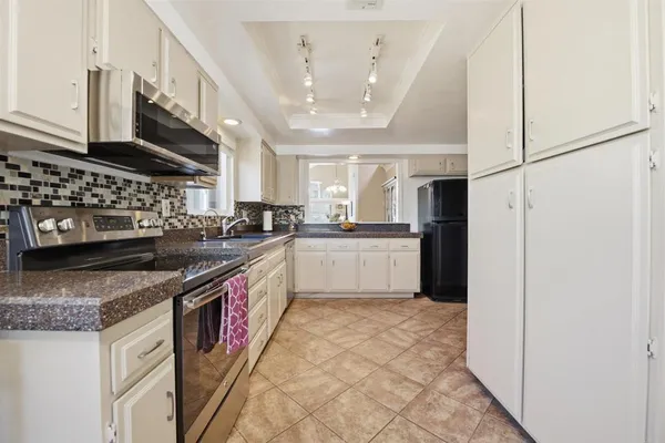 a kitchen with stainless steel appliances granite countertop a stove a sink and a refrigerator
