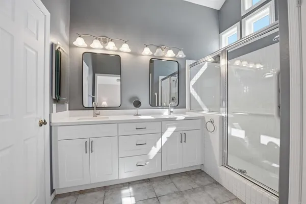 a bathroom with a double vanity sink and a mirror