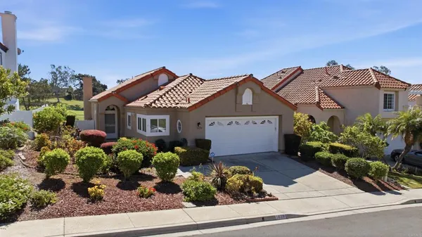 front view of a house with a big yard and potted plants