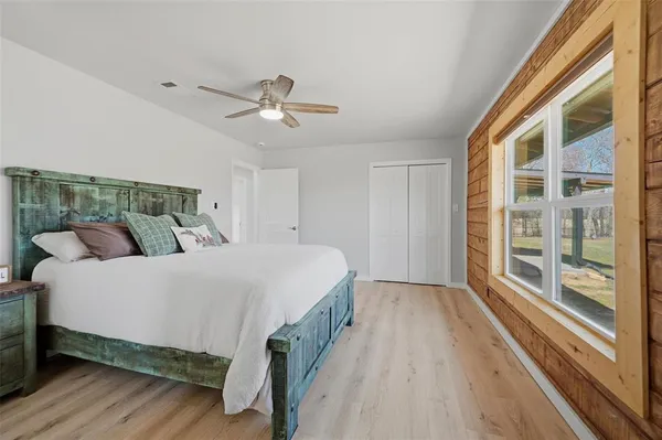 a bedroom with a bed and a large window