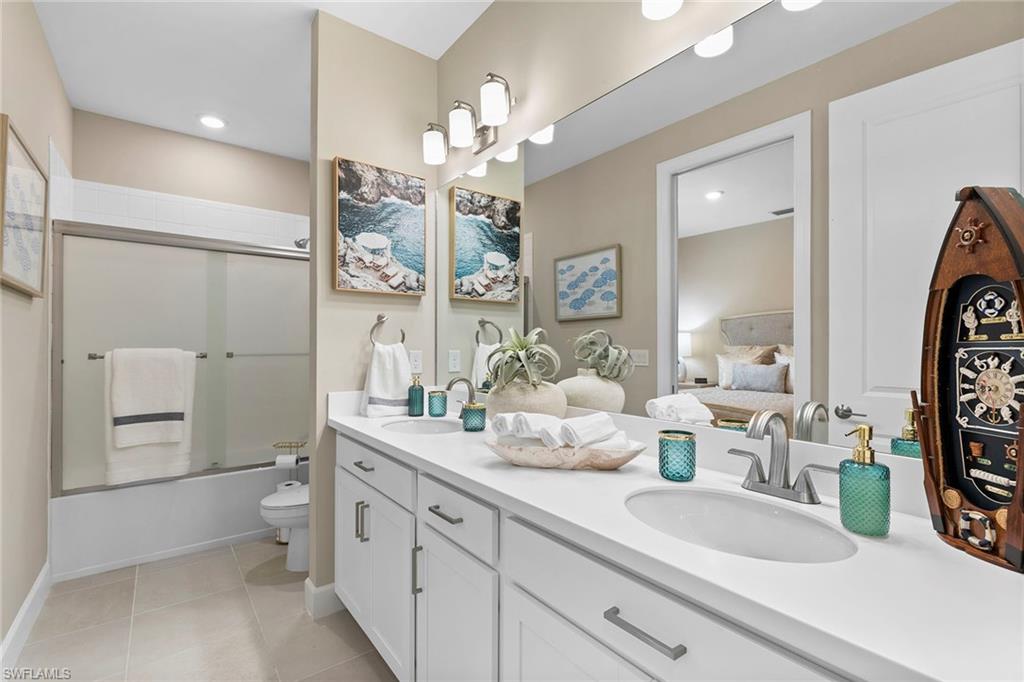 15189 Sacile Court Naples, FL 34114 - Photo 21 of 30 a spacious bathroom with a double vanity sink toilet and a mirror