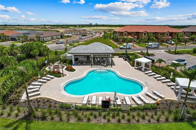 an aerial view of a swimming pool with outdoor seating and yard