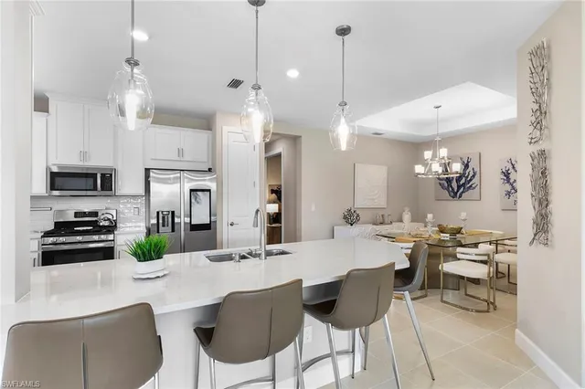 a kitchen with a sink refrigerator and cabinets