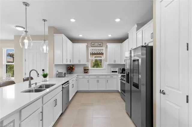 a very nice looking dining room with kitchen island stainless steel appliances a table and chairs