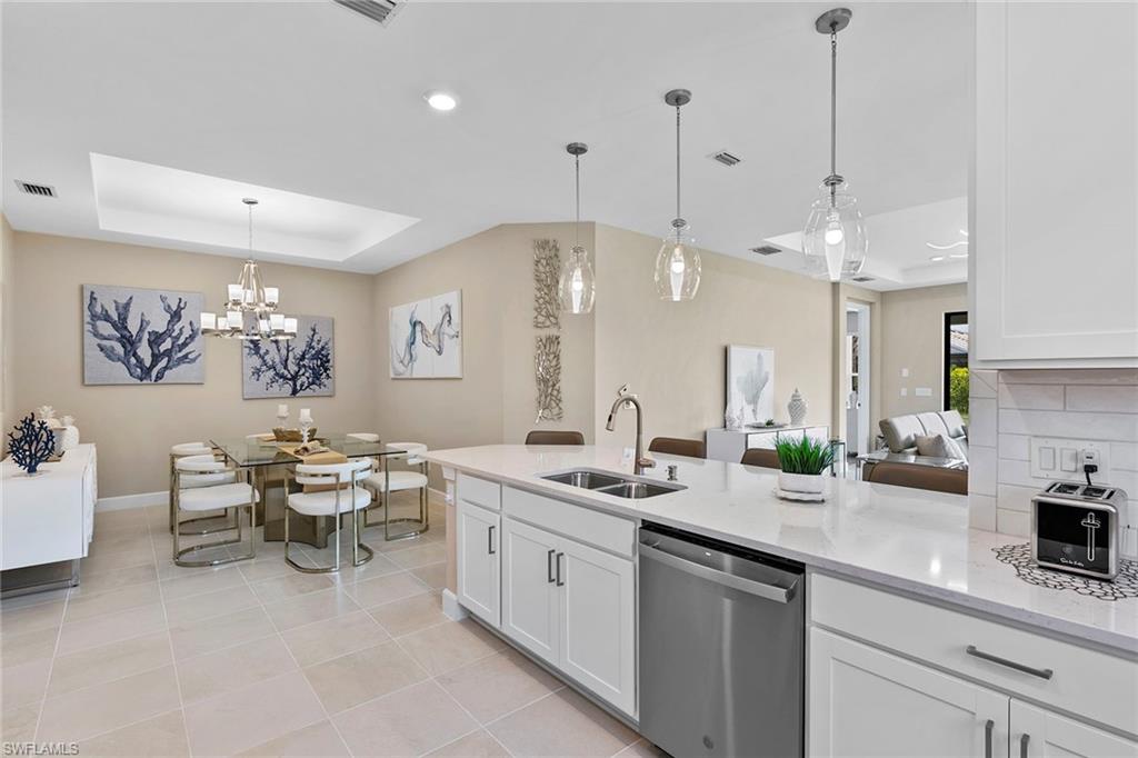 15189 Sacile Court Naples, FL 34114 - Photo 10 of 30 a very nice looking dining room with kitchen island stainless steel appliances a table and chairs