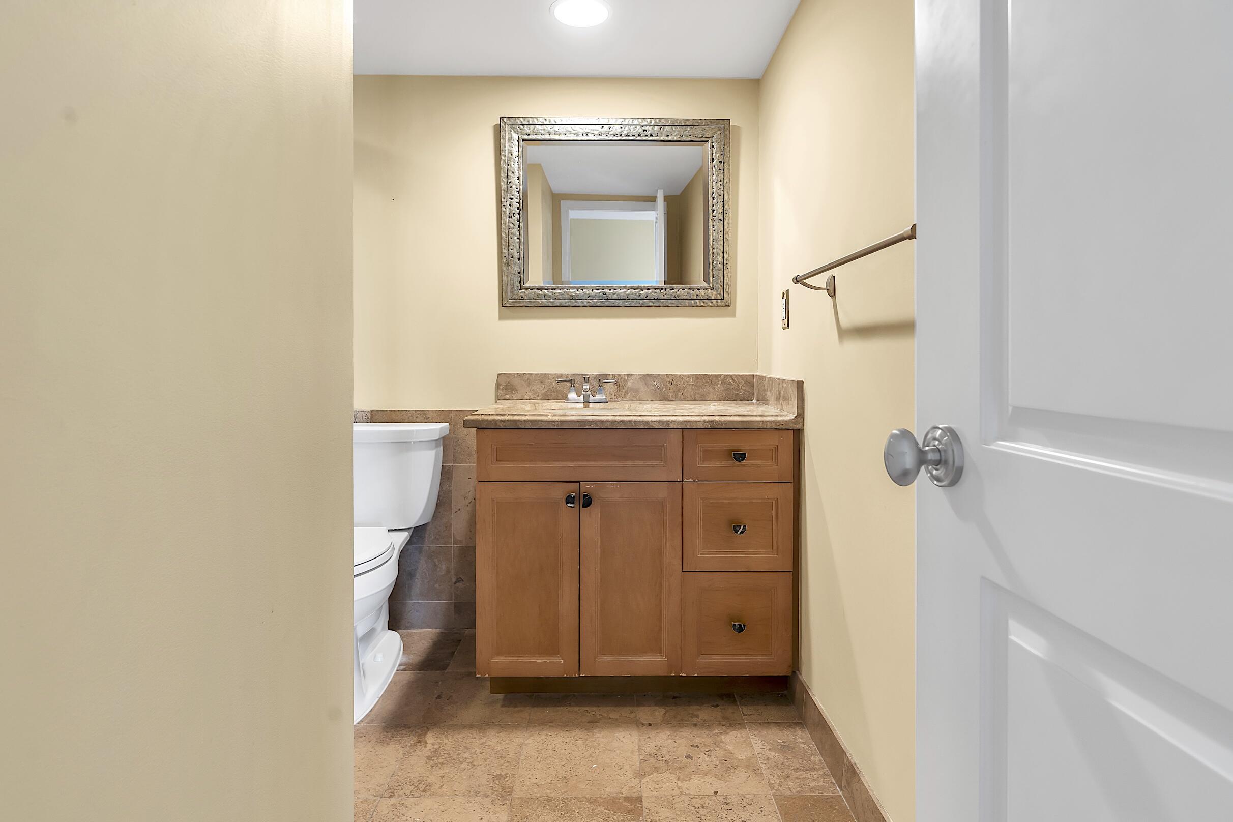 2500 East Las Olas Boulevard, Unit 802 Fort Lauderdale, FL 33301 - Photo 37 of 67 a bathroom with a granite countertop sink a toilet and a mirror