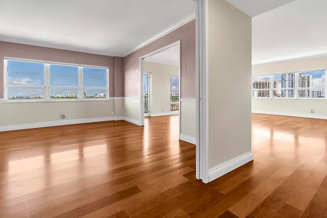 a view of empty room with wooden floor and fan