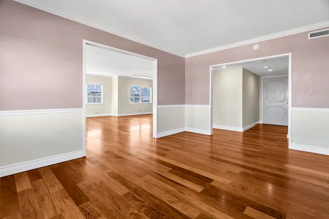 a view of a room with wooden floor and a window