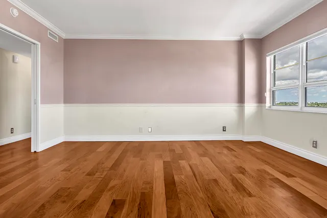 a bedroom with a bed a mirror and a large window