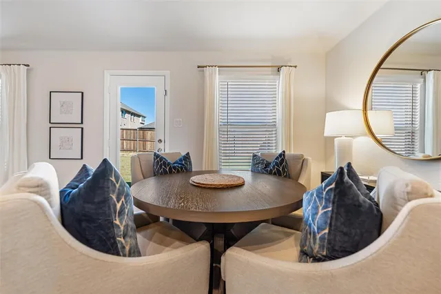 a living room with table and a mirror