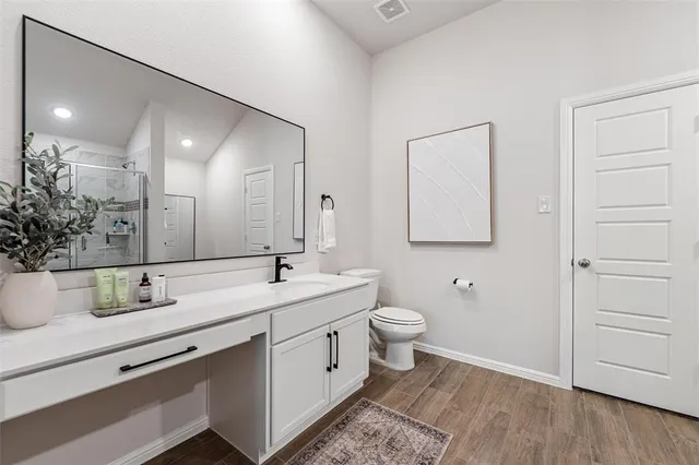 a bathroom with a toilet sink and mirror