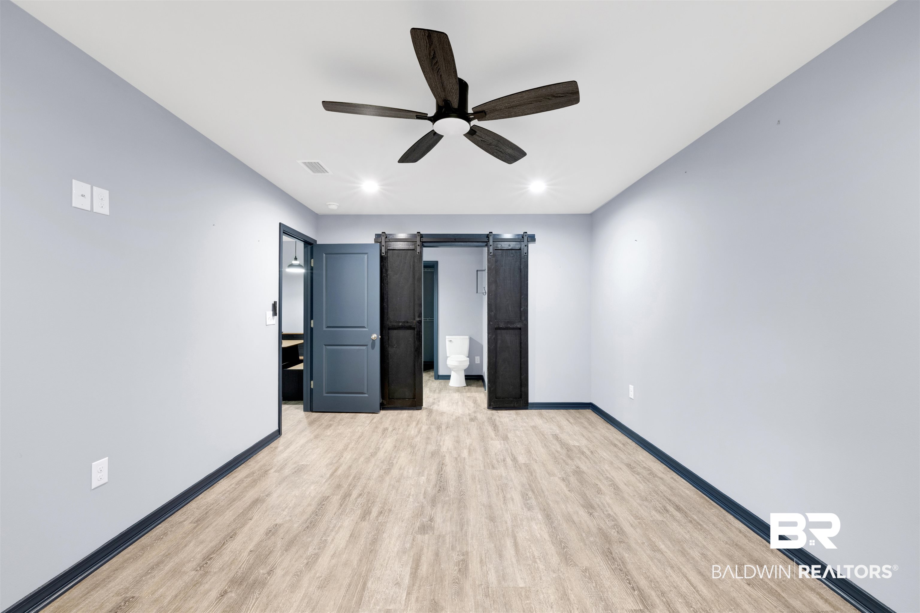 36397 Alexandria Trail Stapleton, AL 36578 - Photo 50 of 65 Unfurnished bedroom featuring a barn door, light wood finished floors, connected bathroom, a ceiling fan, and recessed lighting