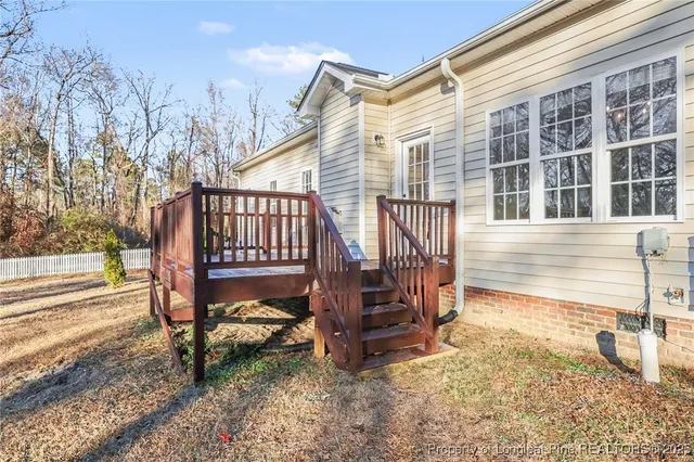 a view of house with a bench in the yard