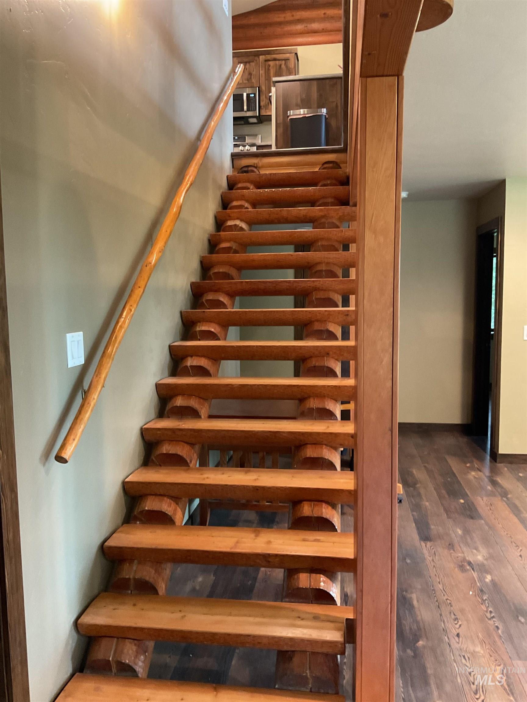 6125 Freeman Creek Road Lenore, ID 83541 - Photo 28 of 44 Rustic wood staircase with log-style railings and wood-finish flooring