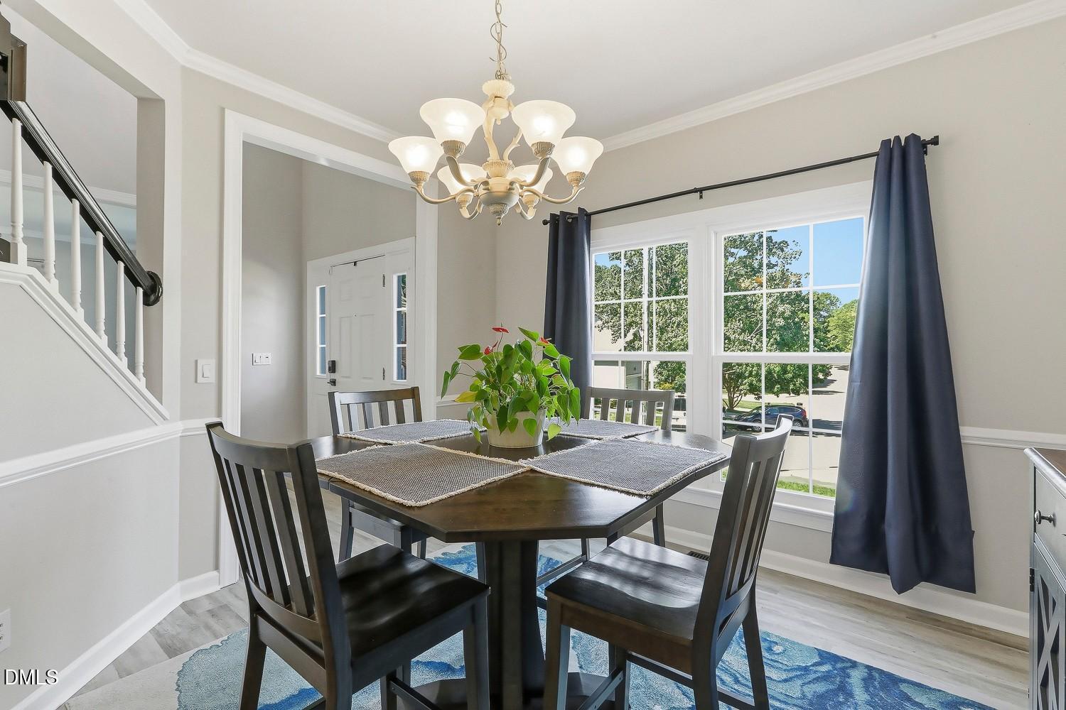 4001 Batiste Road Raleigh, NC 27613 - Photo 22 of 63 a view of a dining room with furniture a chandelier and wooden floor