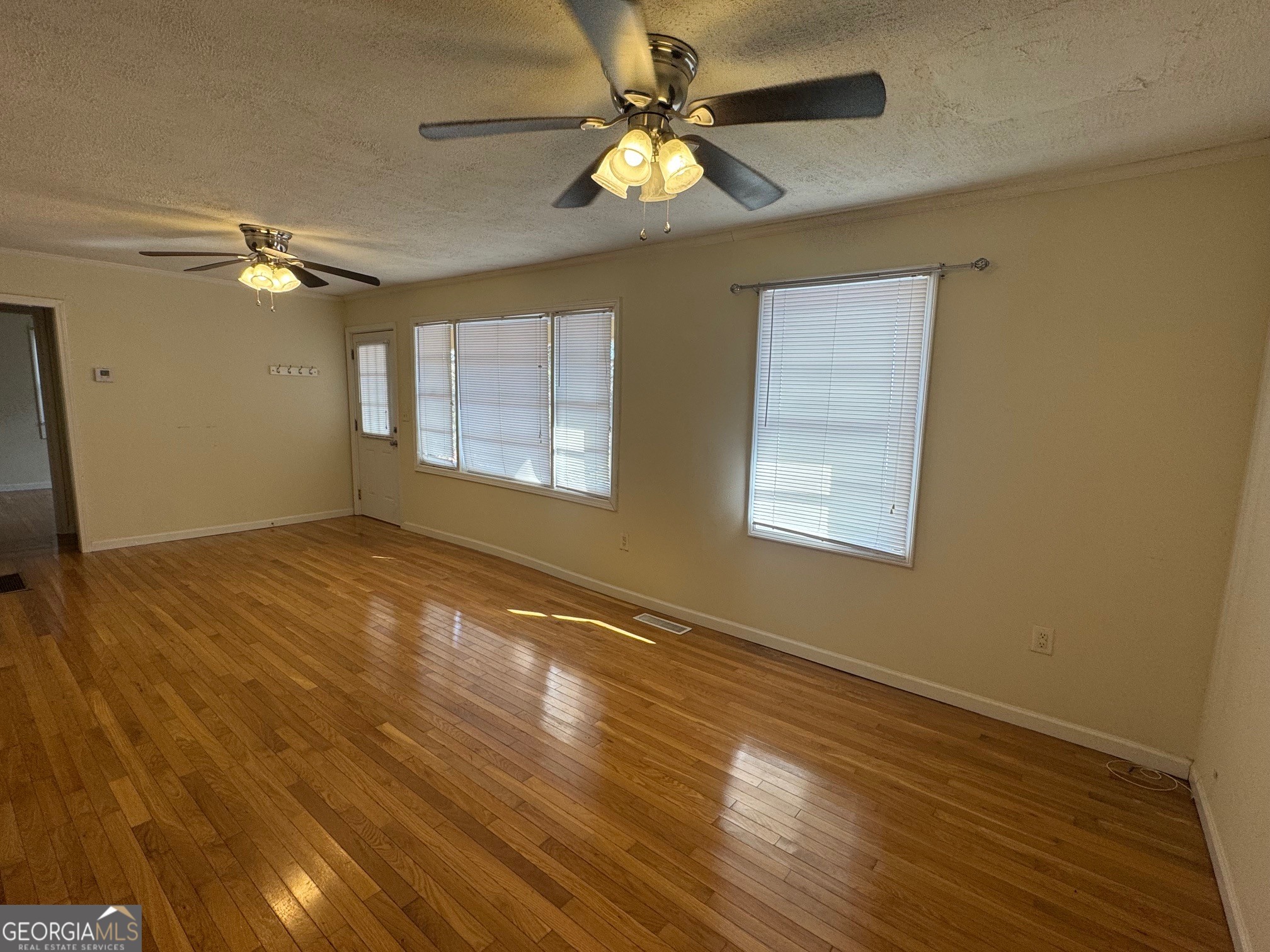 2574 Wire Bridge Road Arnoldsville, GA 30619 - Photo 2 of 10 a view of empty room with wooden floor and fan