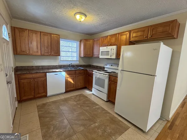 a kitchen with stainless steel appliances granite countertop a refrigerator stove a sink dishwasher and wooden cabinets