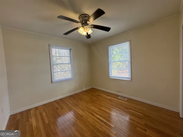 a view of empty room with wooden floor