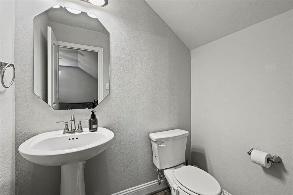 105 Melody Way Red Oak, TX 75154 - Photo 24 of 27 a bathroom with a toilet sink and mirror