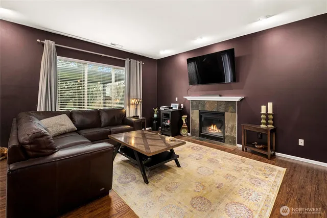 a living room with furniture a flat screen tv and a fireplace