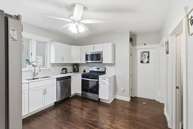 a kitchen with white cabinets and stainless steel appliances