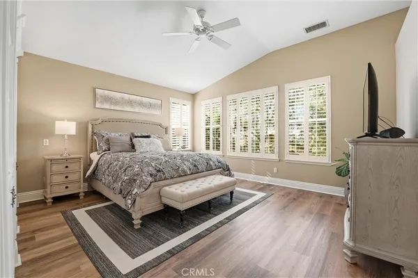 a bedroom with a bed a large window and flat screen tv