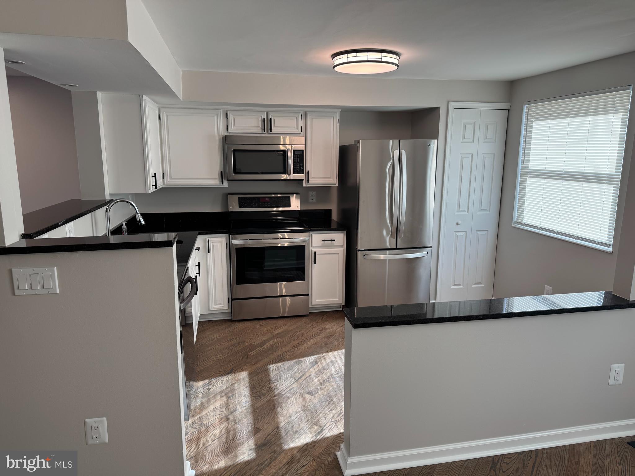 6366 Bonham Place Centreville, VA 20121 - Photo 1 of 18 a kitchen with stainless steel appliances granite countertop a refrigerator a stove a sink and a microwave