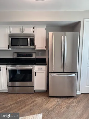 a kitchen with stainless steel appliances granite countertop a stove top oven and microwave