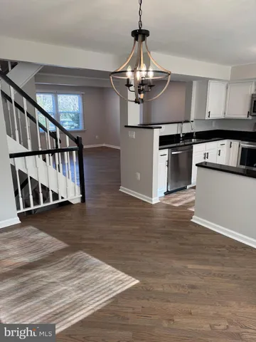 a view of a kitchen with stainless steel appliances granite countertop a stove and wooden floor