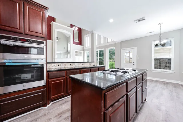 a kitchen with granite countertop a sink stove and cabinets