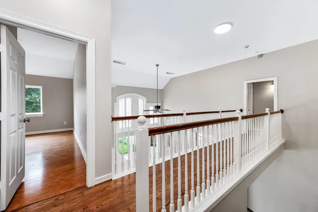 a view of a hallway with entryway and wooden floor