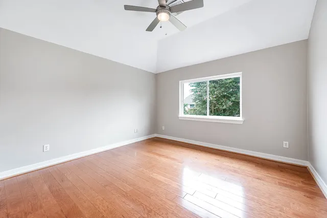 an empty room with a window and a ceiling fan