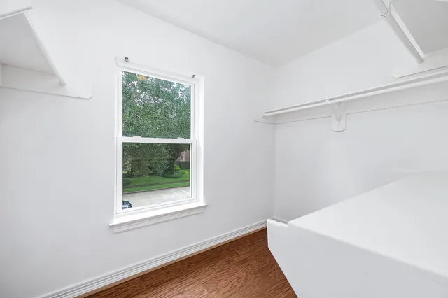 a view of a room with wooden floor and window