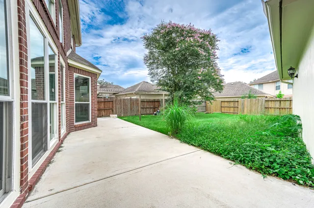 a view of a brick house with a yard and potted plants