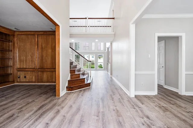 a view of a hallway with wooden floor and staircase