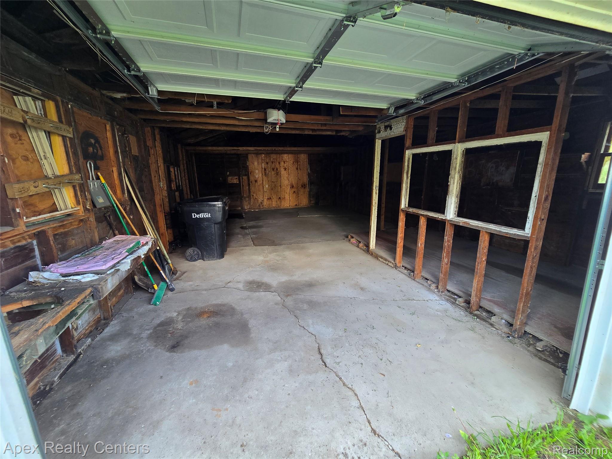 7671-7675 Evergreen Road Detroit, MI 48228 - Photo 17 of 84 One-car garage with a panel garage door, concrete flooring, and exposed wood framing
