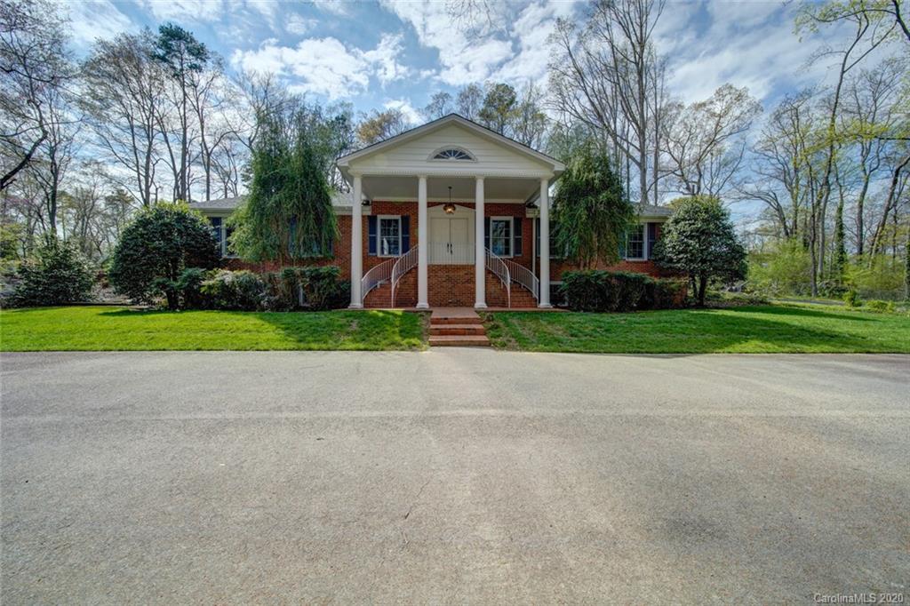 a front view of a house with a yard and trees