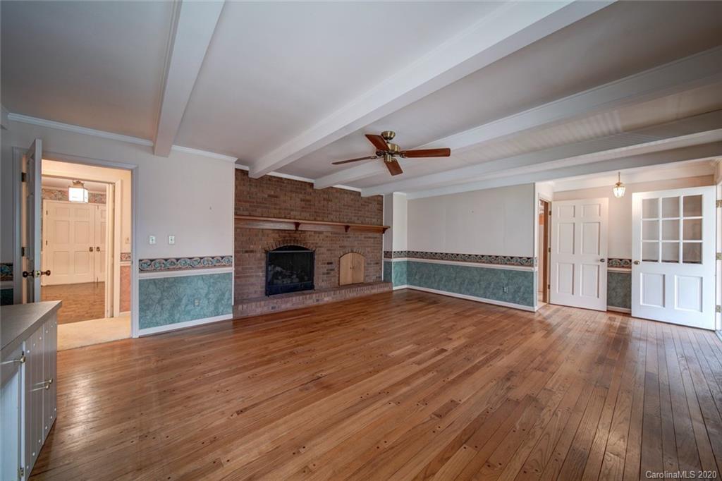 1415 Melchor Road Albemarle, NC 28001 - Photo 11 of 47 an empty room with wooden floor fireplace and windows
